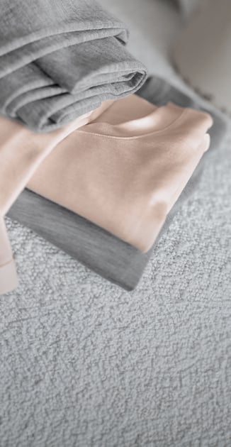On y voit deux hauts et deux leggings de la série True Confidence dans les couleurs rose et grise.