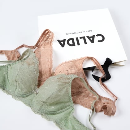 Two lace bras are lying on a CALIDA shopping bag.