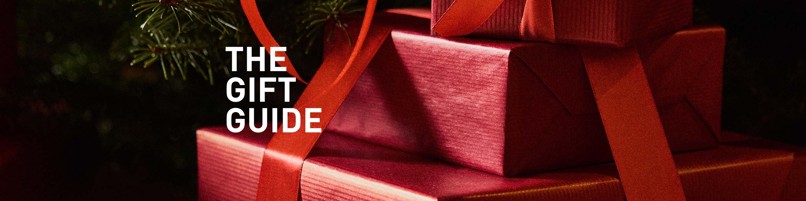 Festively wrapped gift boxes in bright red, staged as an atmospheric introduction to the CALIDA Gift Guide.