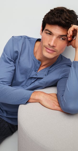 Der Mann trägt einen Pyjama, lang aus der Serie Relax Imprint 1 in der Farbe blau.