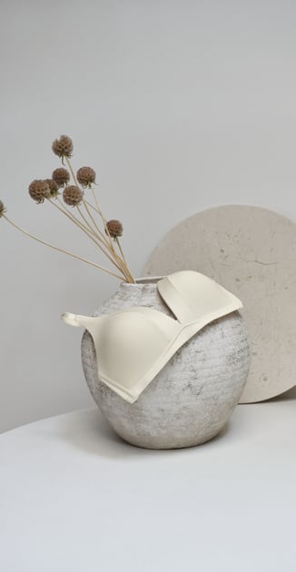 Wire-free soft bra from the Cate series in cream, displayed on a vase.