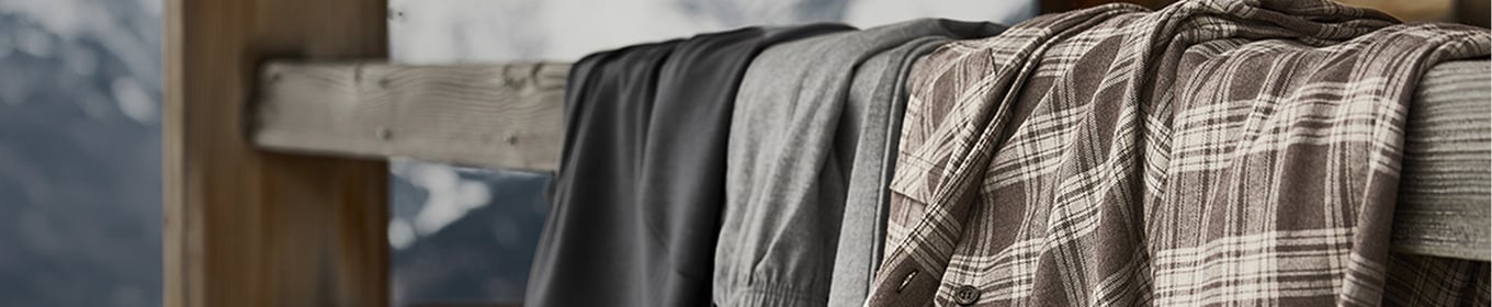 Vue détaillée d'un long t-shirt gris clair en matériau doux, porté sur le corps et mettant l'accent sur la coupe ajustée et moulante.