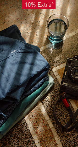 Table with a pile of men pyjamas on it.