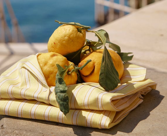 The picture shows a pile of a top and bottom piece of a yellow striped pyjama.