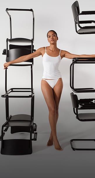 Die Dame trägt ein Spaghetti-Top mit dem passenden Tanga-Slip der Serie Sleek Skin in weiß.