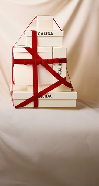 Eine Ansammlung von Geschenken mit rotem Geschenkband auf denen CALIDA steht.