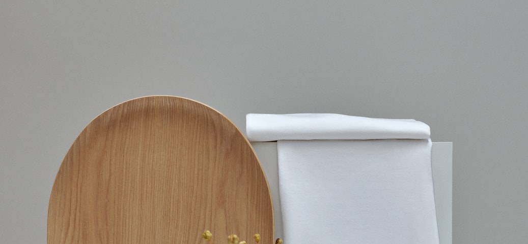 Spaghetti-Top von CALIDA aus der Serie Benefit Women, stilvoll arrangiert vor minimalistischer Kulisse mit Holztablett und Vase