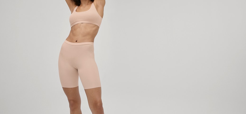 Frau trägt hautfarbene Radlerhose und Bustier aus der CALIDA Serie Natural Skin – ideal zum Tragen unter einem Kleid.
