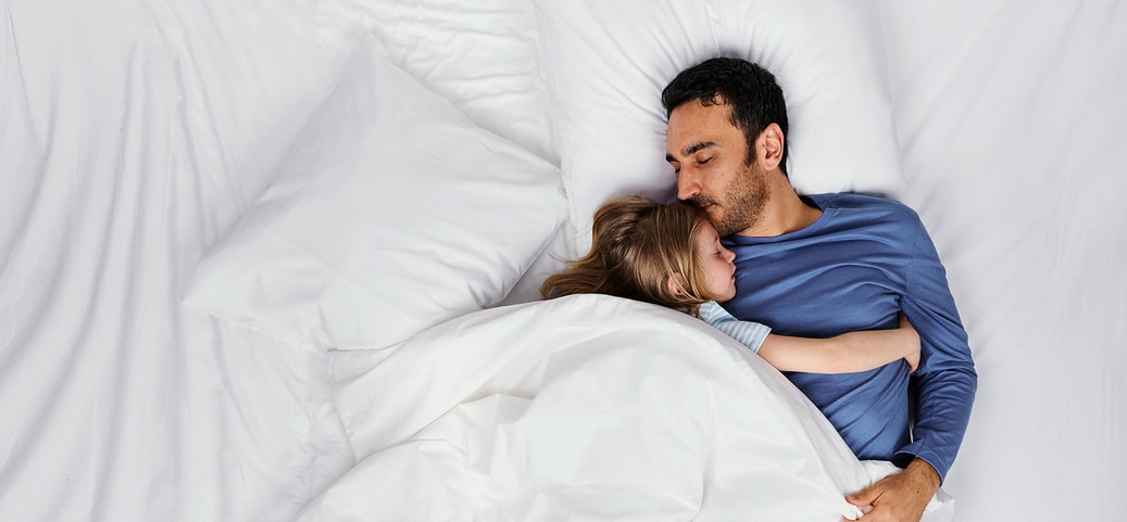 Zwei Personen schlafen ruhig im Bett; Szene symbolisiert erholsamen Tiefschlaf und Wege, ihn zu verbessern