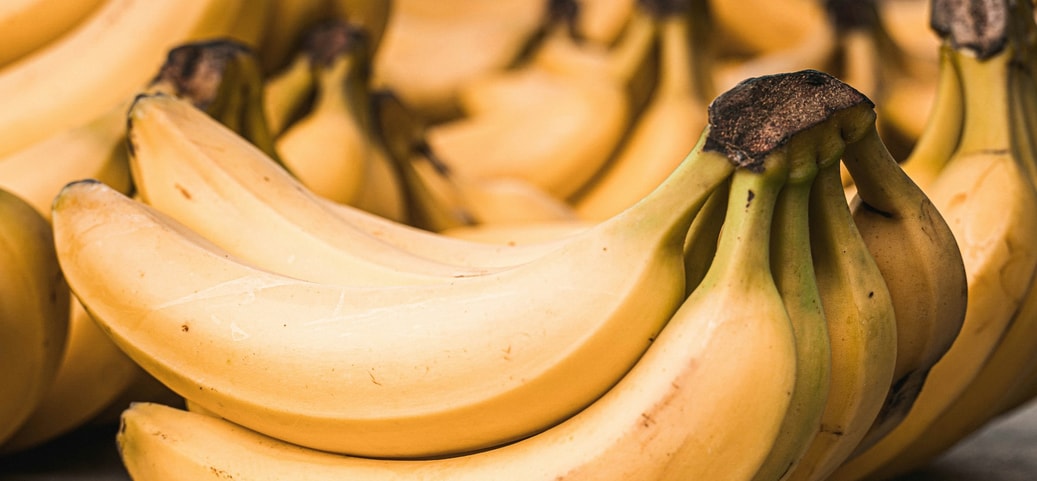 Several ripe yellow bananas on a surface; symbolic image for the topic banana before going to sleep