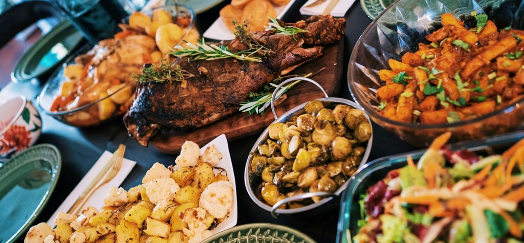 Verschiedene Gerichte und Speisen auf einem gedeckten Tisch, schön arrangiert und bereit zum Essen.