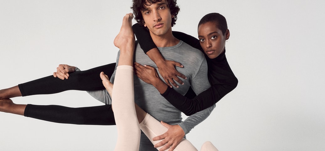 Tre persone in abiti di seta semplici e aderenti posano ad arte. Gli abiti simboleggiano eleganza e comfort: l'ideale per i consigli su come lavare la seta.