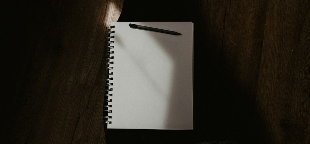 Sleep diary with pen lies on a person's lap.