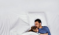 Two people sleeping peacefully in bed; scene symbolises deep restorative sleep and ways to improve it