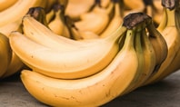 Plusieurs bananes jaunes mûres sur une surface ; image symbolique pour le thème de la banane avant d'aller dormir.