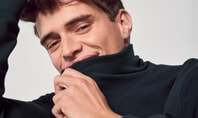 Homme en Basic Loungewear de CALIDA, souriant et détendu face à la caméra, tirant légèrement le col roulé de son haut sur le menton.