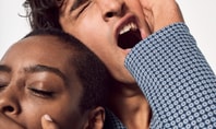 The picture shows a man and a woman in close proximity to each other, both yawning tiredly. The man is leaning his head on the woman's while they are wearing CALIDA pyjamas. The scene conveys a familiar and cosy atmosphere of domestic togetherness.