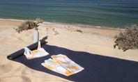 Yoga mat with yoga clothing from CALIDA on the beach