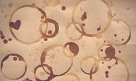 Molteplici macchie di caffè marrone sulla carta, simili alle tipiche macchie di caffè sui vestiti.