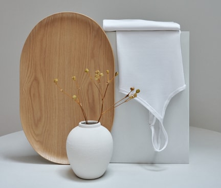 Spaghetti-Top von CALIDA aus der Serie Benefit Women, stilvoll arrangiert vor minimalistischer Kulisse mit Holztablett und Vase