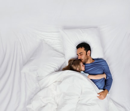 Zwei Personen schlafen ruhig im Bett; Szene symbolisiert erholsamen Tiefschlaf und Wege, ihn zu verbessern