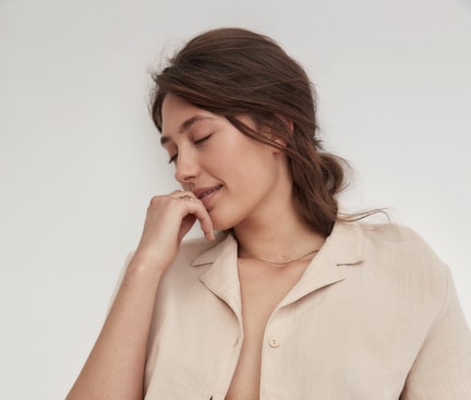 Woman wearing an open shirt and white regular‑cut slip from the CALIDA Essential Cotton series against a light background