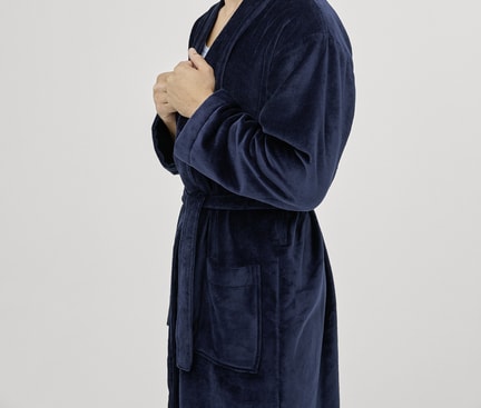Person wearing a dark blue CALIDA bathrobe from the After Shower collection, standing sideways against a light background.