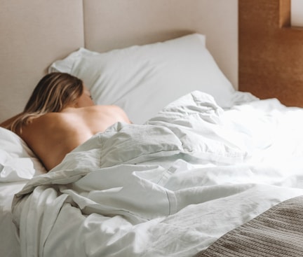 Frau die auf dem Bauch im Bett liegt