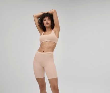Frau trägt hautfarbene Radlerhose und Bustier aus der CALIDA Serie Natural Skin – ideal zum Tragen unter einem Kleid.