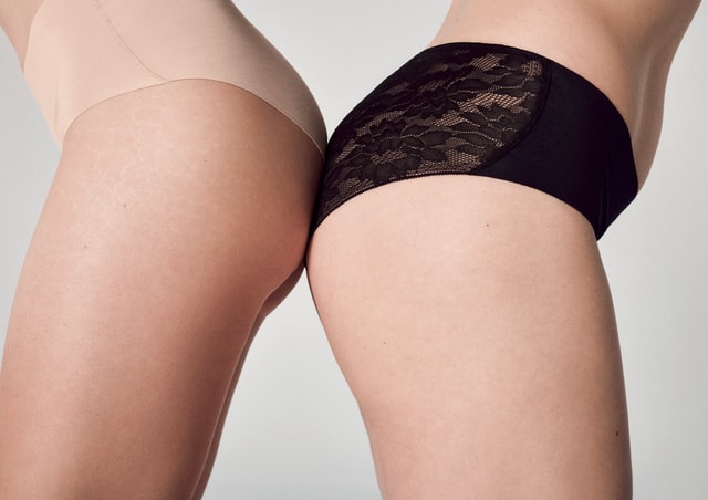 Deux femmes portant de la lingerie CALIDA de la série Natural Skin – culottes sans couture beige et noire avec dentelle.