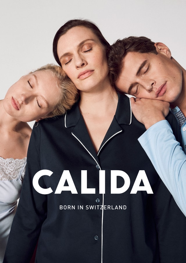 Three people with closed eyes lean against each other and sleep in cosy nightwear. CALIDA - Born in Switzerland.