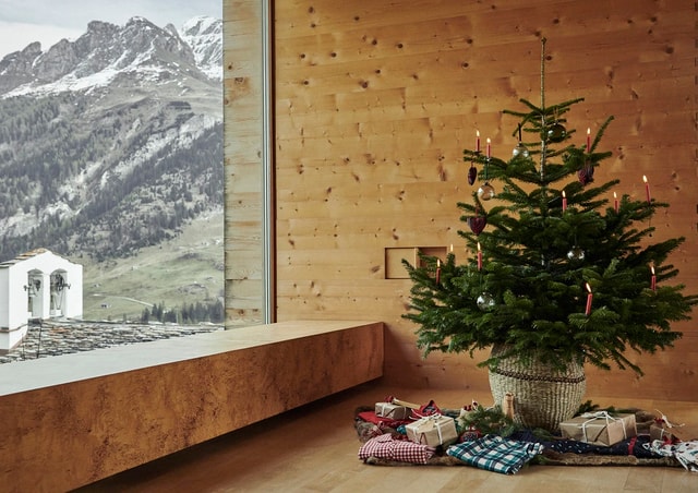 Auf dem Bild ist ein Christbaum mit Geschenken darunter zu sehen. Unteranderem liegen auch Produkte aus der neusten Serie Favourites Holidays und Family & Friends von CALIDA unter dem weihnachtlich geschmückten Tannenbaum.