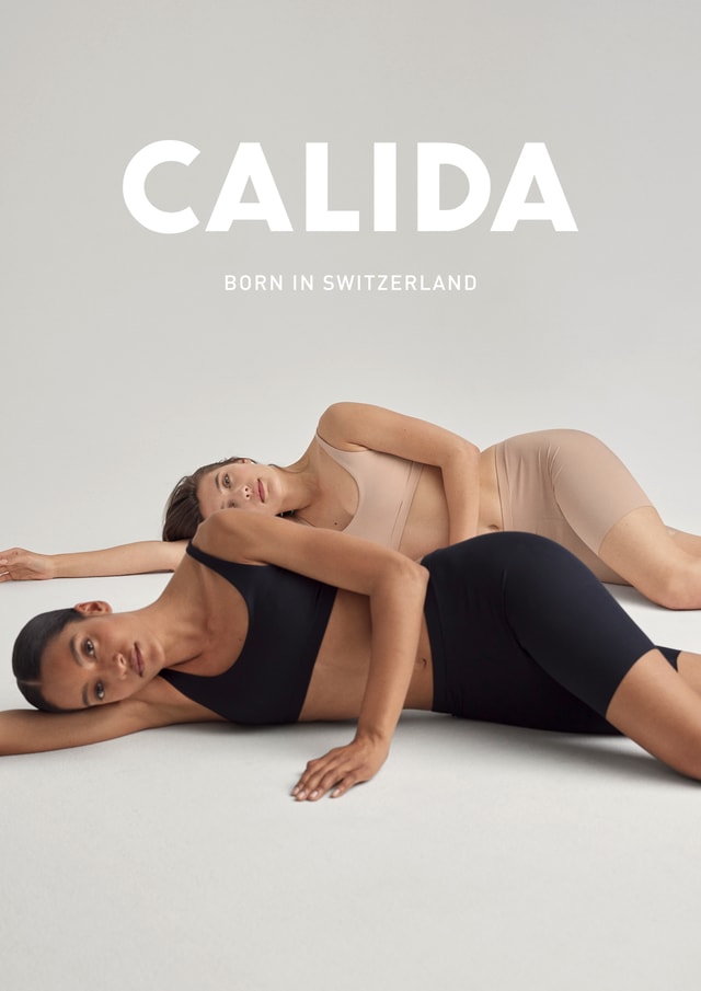 Two women lying on the floor wearing skin-toned and black cycling shorts with bra tops from CALIDA's Natural Skin series – ideal under dresses.